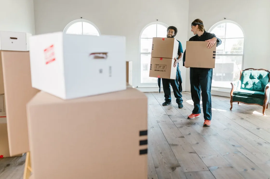 Umzugskartons werden durch einen Raum getragen